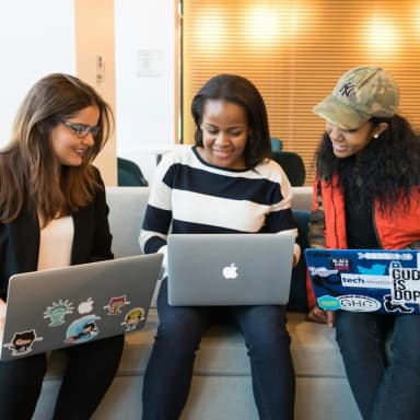 Student working on laptop with mentors